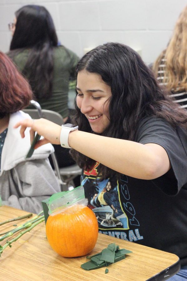 Jessica Garcia, 11, builds a centerpiece in Mindy Camps floral design class. The pumpkin creations are being sold at $10 apiece.