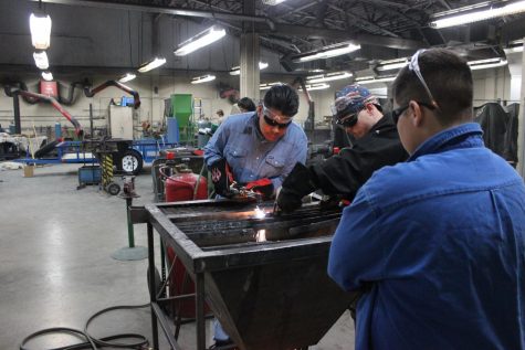 Welding students use a plasma cutter to cut a piece of metal