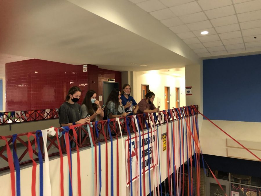 Seniors watch as Principal David Pierce enters the main hallway to witness the cup pyramids and streamers set up by seniors. The prank is a yearly tradition to mark the end of the year for the graduating class.