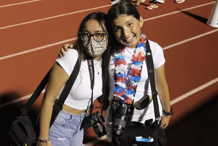 Senior yearbook editors Abi Munoz and Emma-Leigh Thurman capture images of Hays fans in the stands.