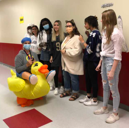 Showing off their costumes, yearbookers posed with Coach Traci Hightower.