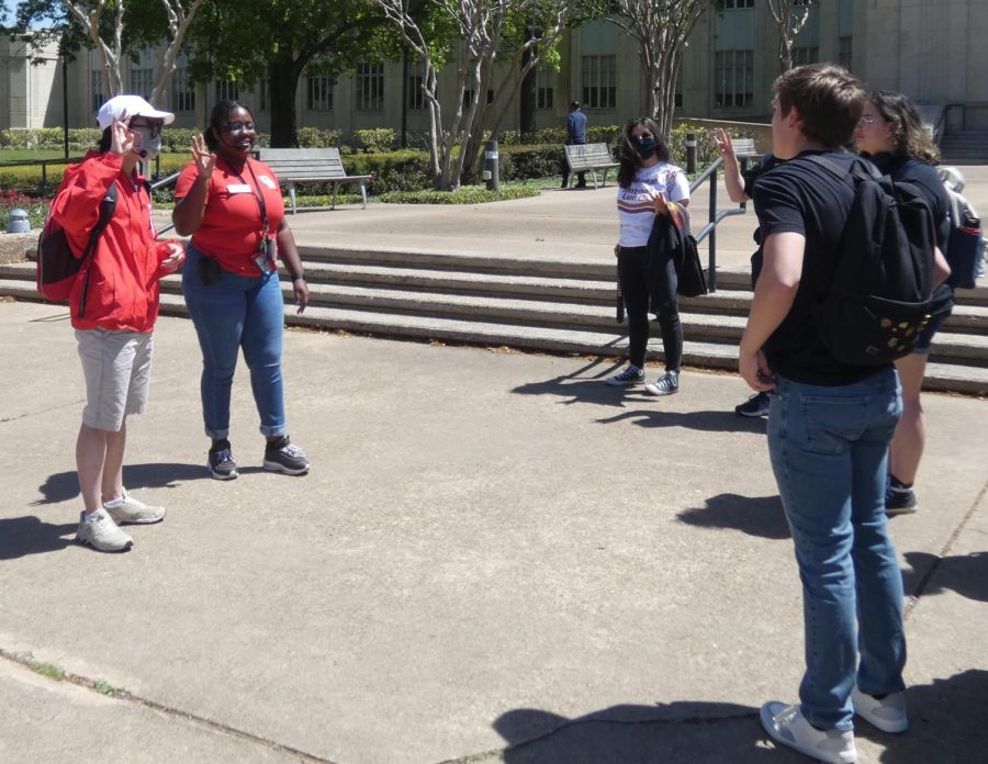 Tour guides show Hays students the hand gesture representing school pride.